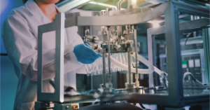 Technician operating advanced cosmetic production machinery for facial mask manufacturing.