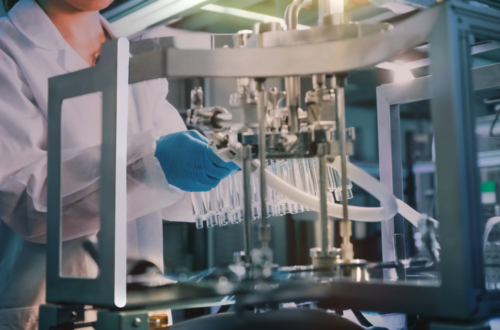 Technician operating advanced cosmetic production machinery for facial mask manufacturing.